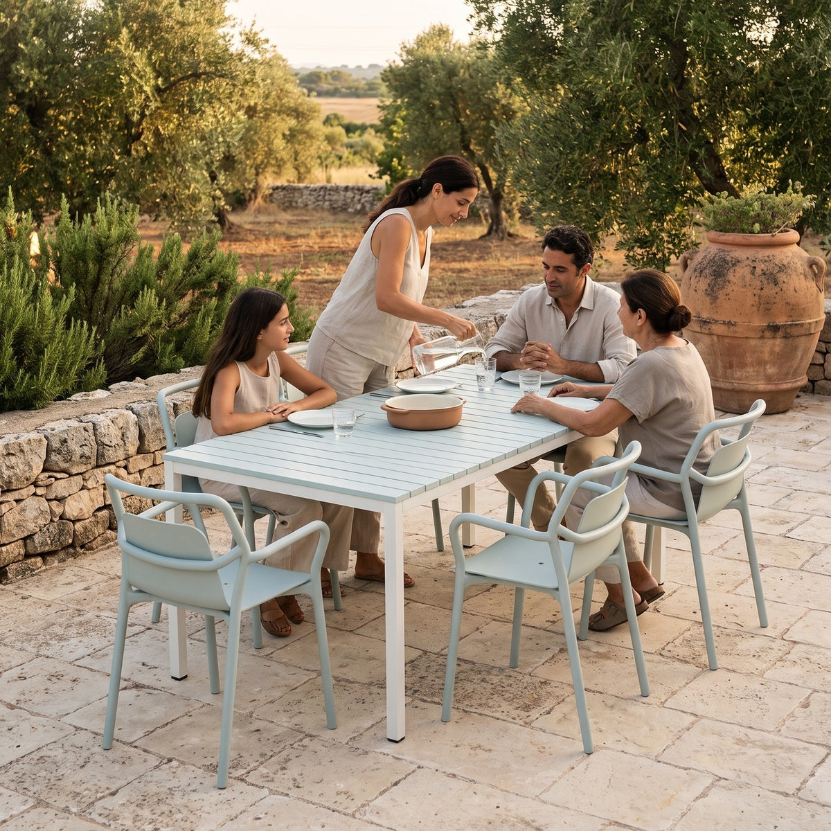 Famille autour du set Shared Table Mia&Mimi Sea Mist sur une terrasse au milieu des oliviers